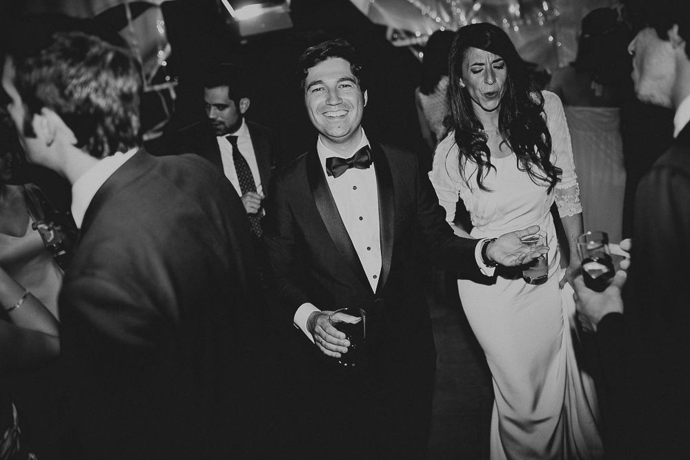 Wedding guests dancing and celebrating at formal evening reception.