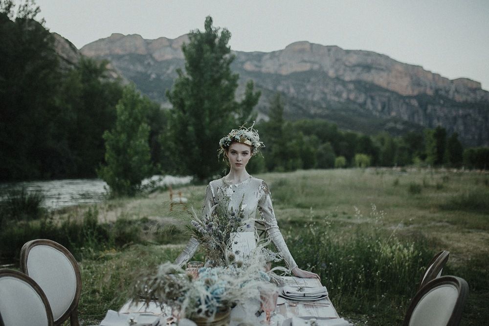 Outdoor mountain wedding table setup with floral arrangements and scenic backdrop.