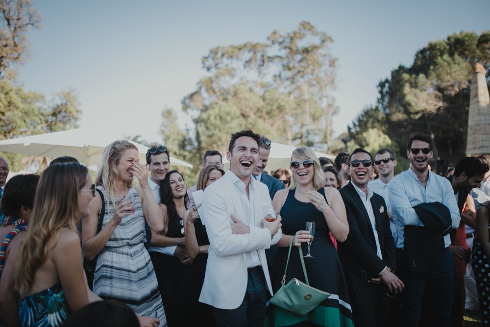 Outdoor party guests enjoying themselves with animated expressions and gestures.