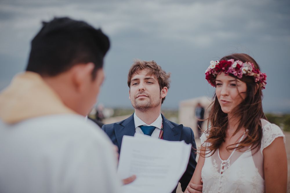 Outdoor wedding ceremony with an officiant leading the service under cloudy skies.