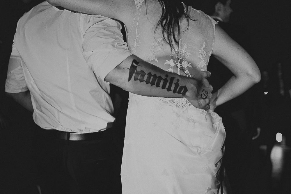 Black and white photo showing the back detail of a wedding dress during a dance.