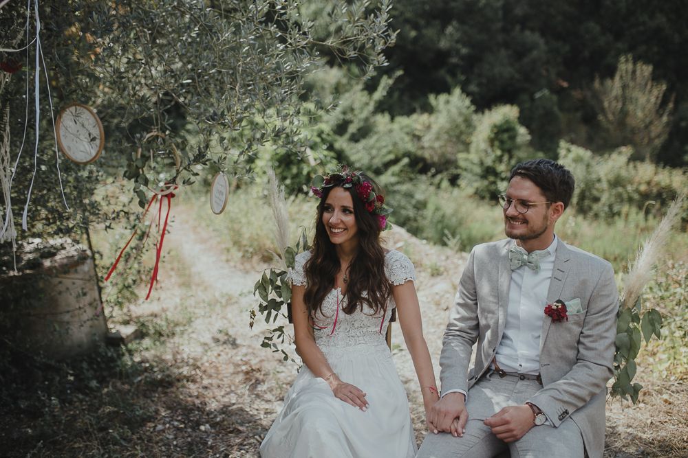 Newlyweds sitting together during outdoor garden wedding celebration.