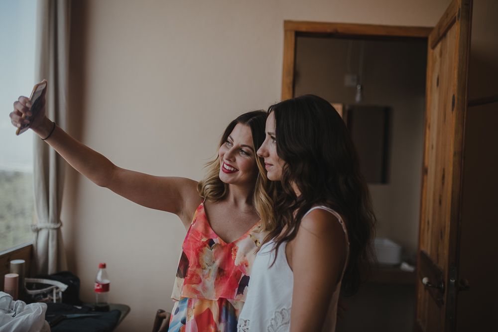Friends taking a joyful selfie together during wedding preparations.