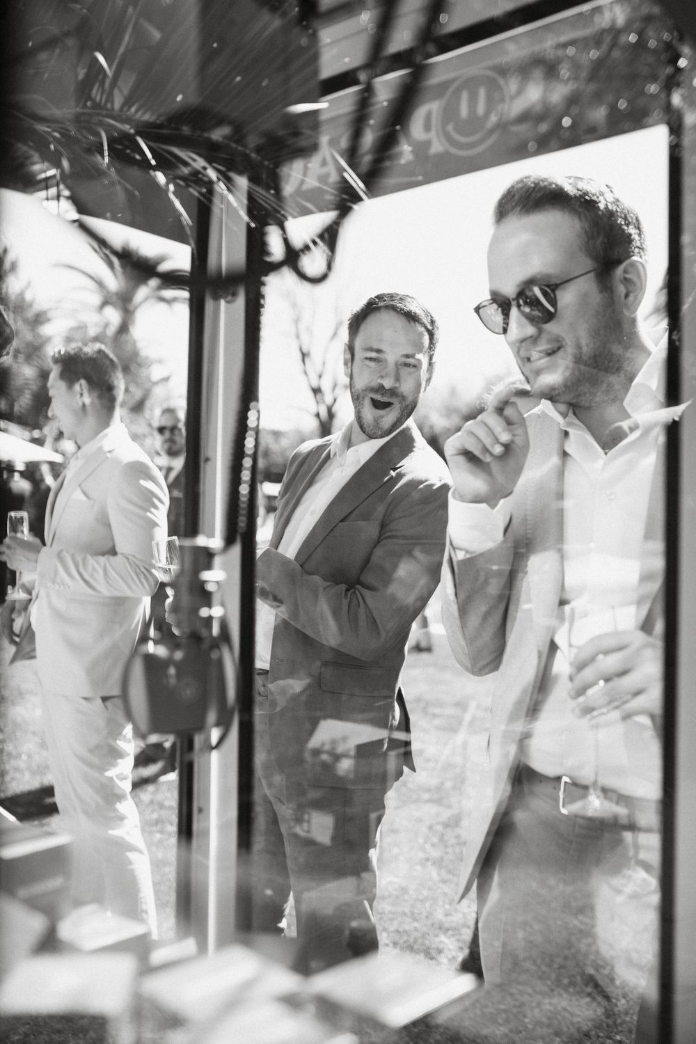Black and white candid photo of guests enjoying themselves at an outdoor event.