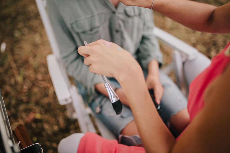 Close-up of hands holding items during an outdoor gathering.