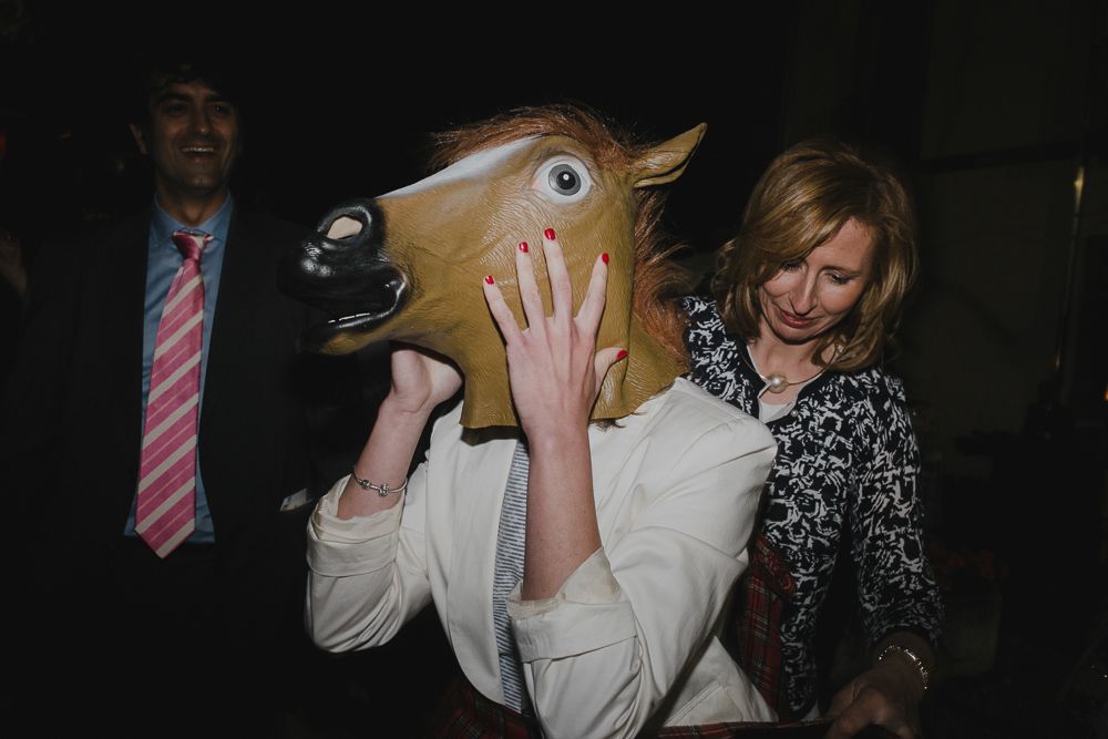 Someone wearing a horse head mask creating a fun moment at a wedding reception.
