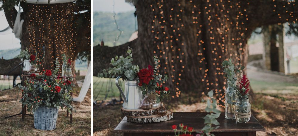 Wedding reception decor with hanging string lights and floral centerpieces in glass vases.