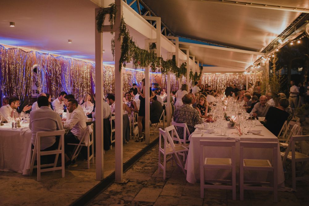 Elegant wedding reception venue decorated with twinkling lights and hanging greenery.