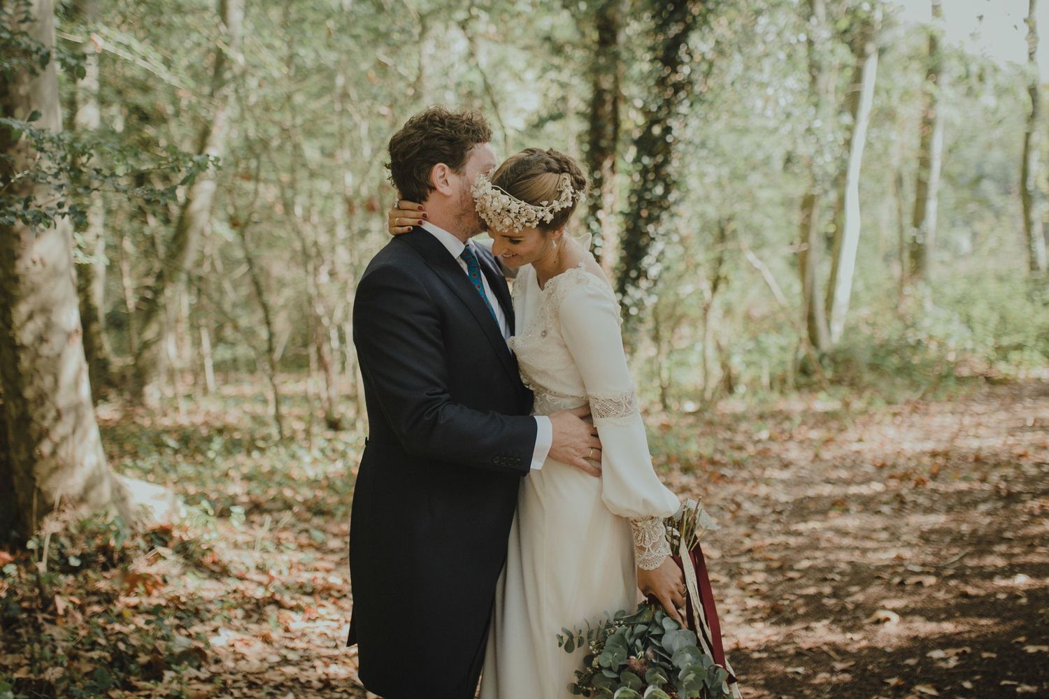 Intimate wedding portrait of couple surrounded by autumn forest scenery.