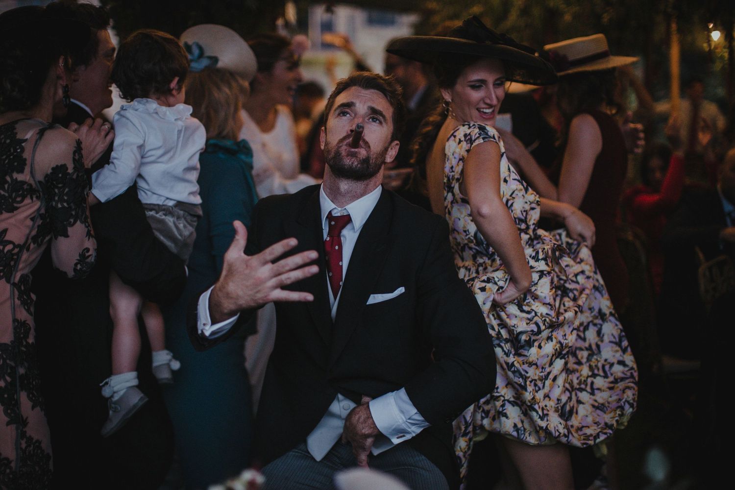 Energetic wedding guests dancing and celebrating at a lively reception party.