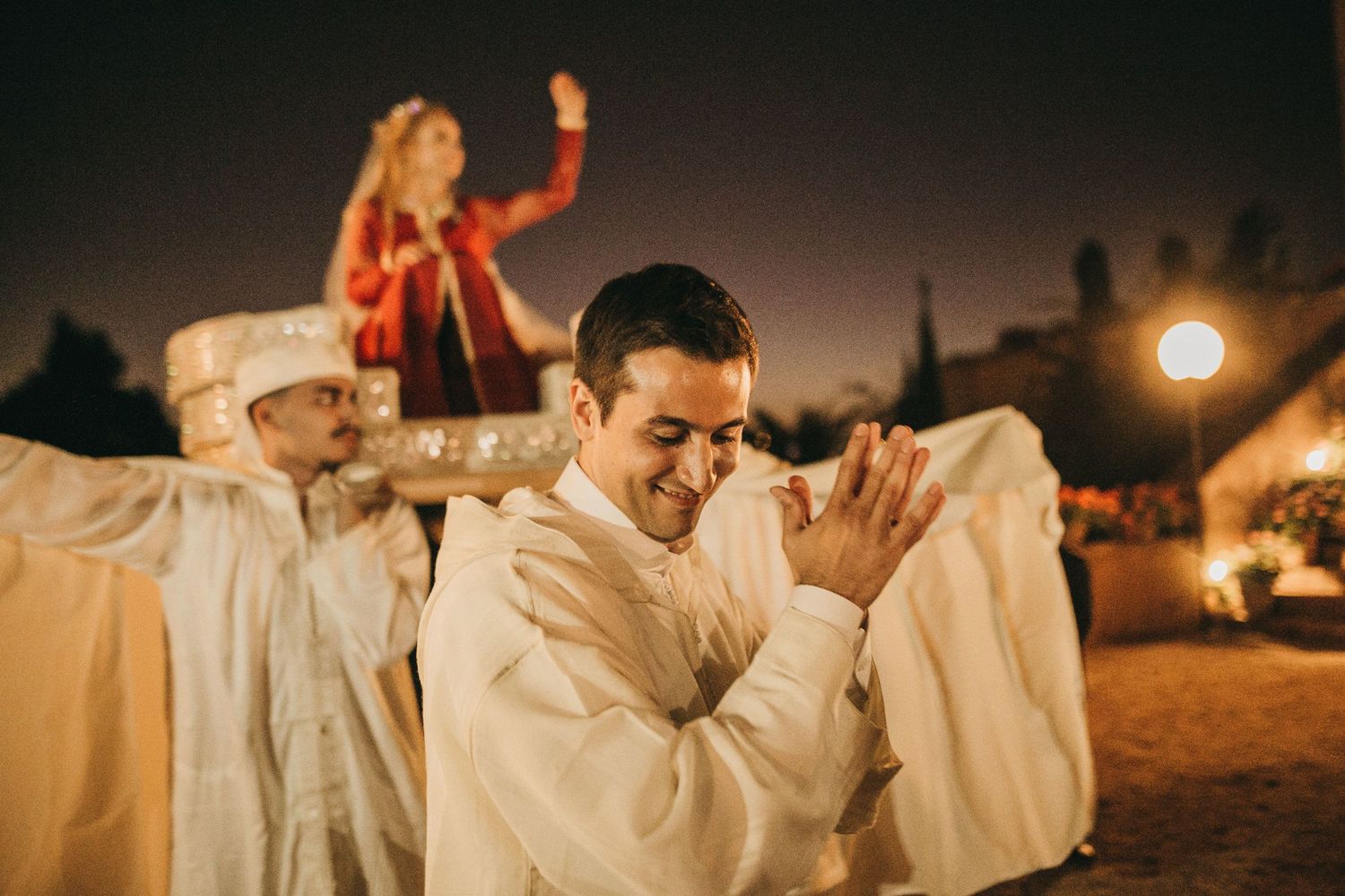 Wedding celebration at night with traditional dancing and flowing white robes.