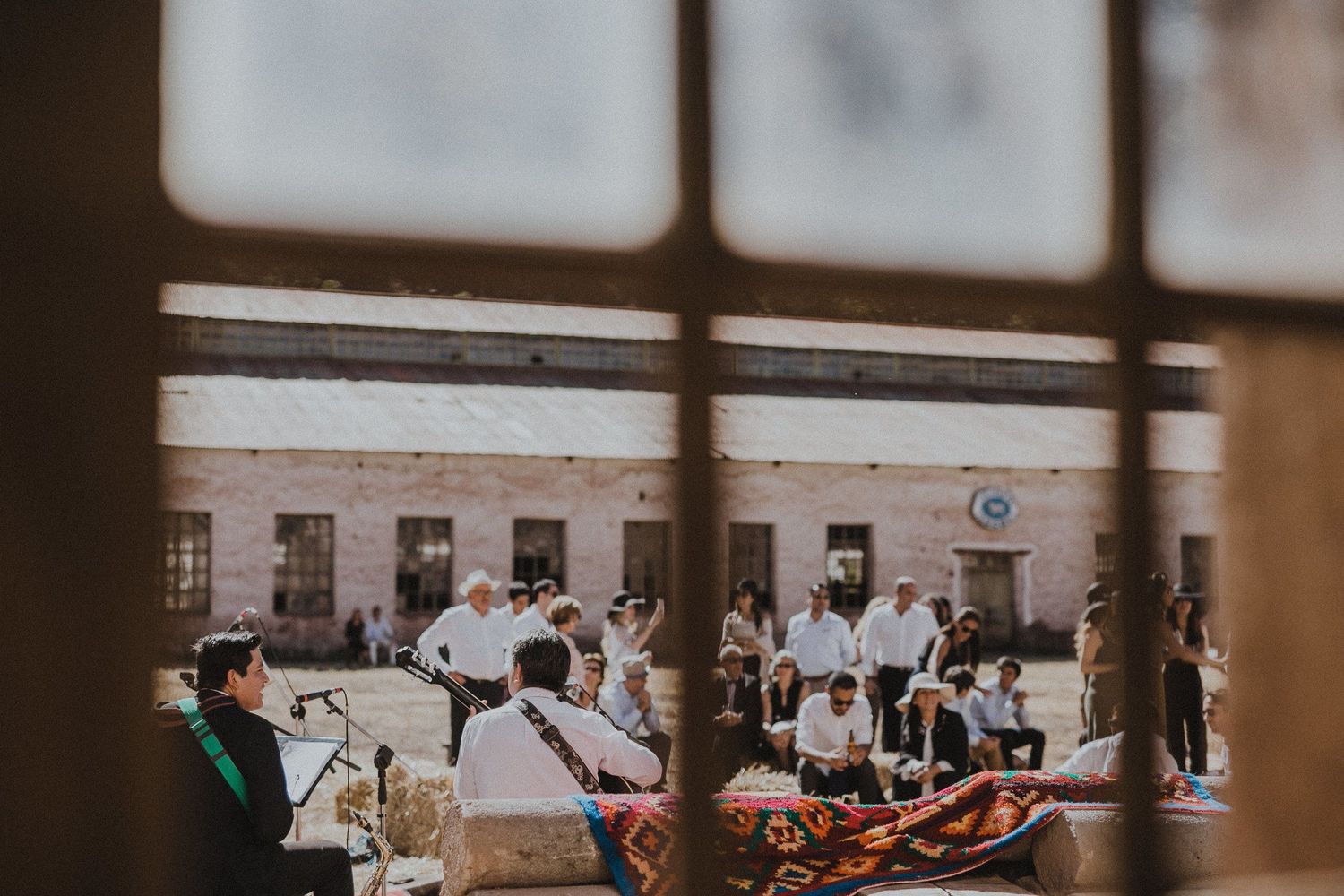 Outdoor gathering space with tables and chairs set up in front of a white building.