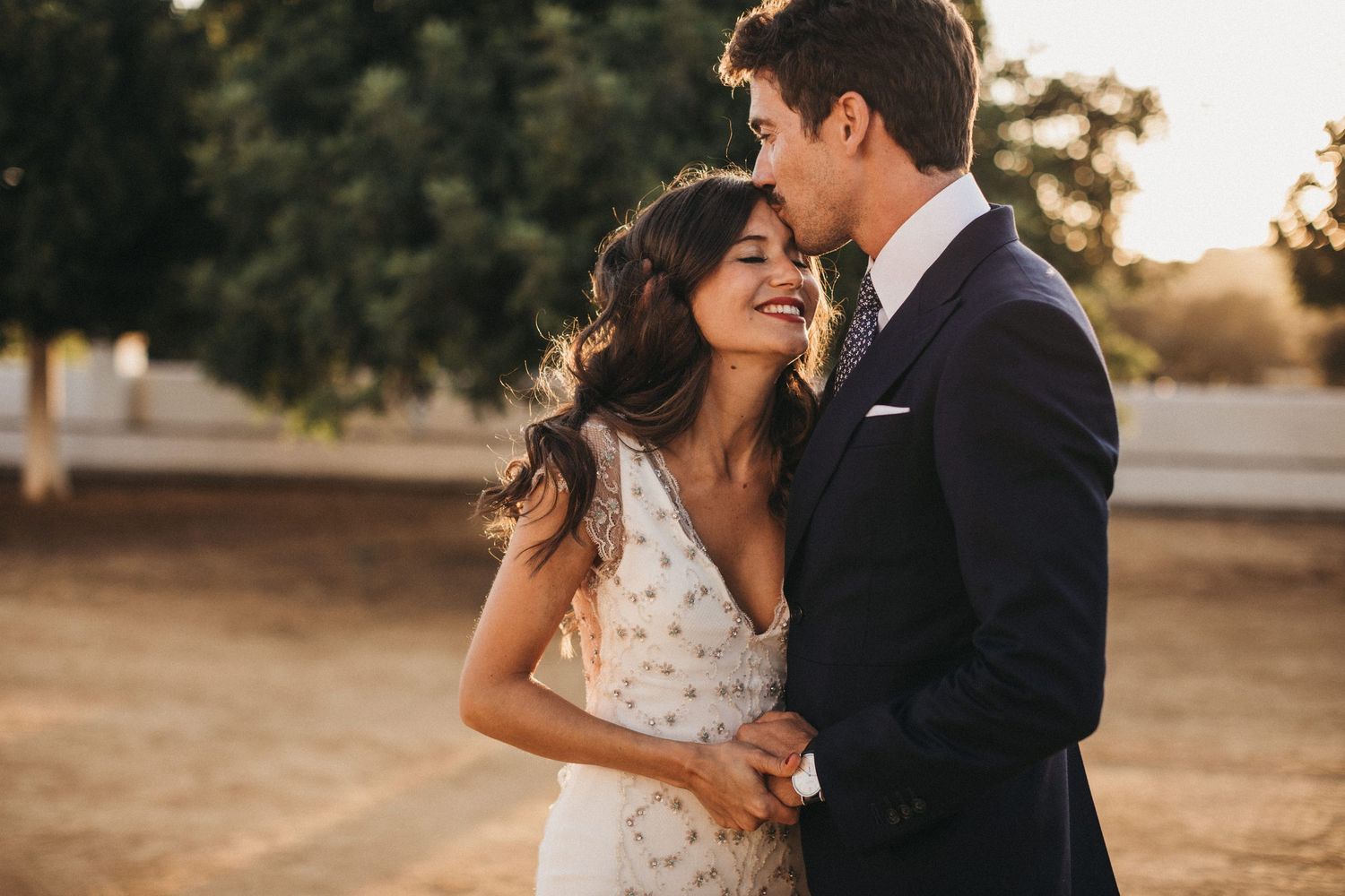 A couple shares joyful moments during their outdoor sunset wedding photoshoot.
