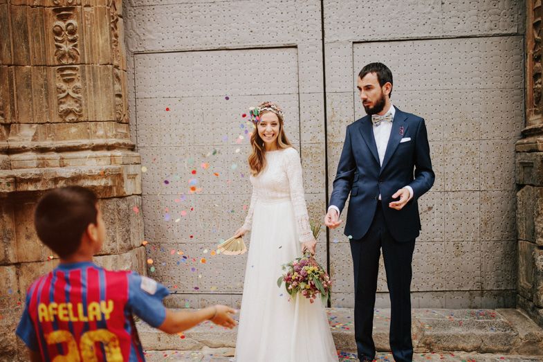 Wedding ceremony with confetti being thrown by child in colorful jersey.