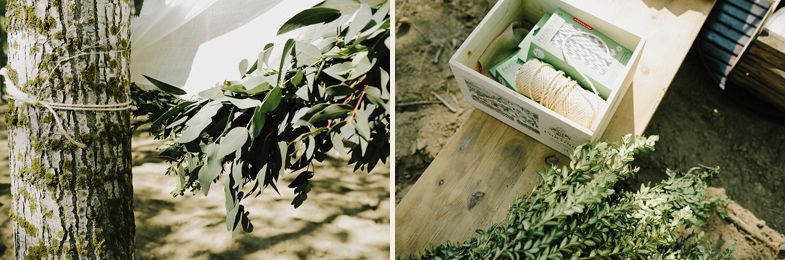 Natural greenery and wedding decor details arranged in rustic wooden boxes.