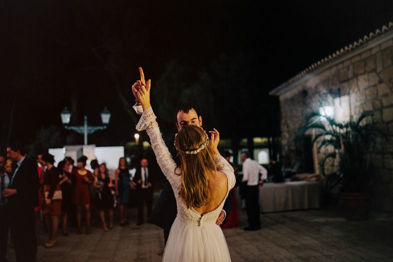 Wedding celebration silhouette of someone raising their arms on the dance floor.