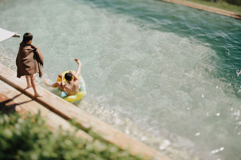High angle view of people enjoying a swim in a turquoise pool.