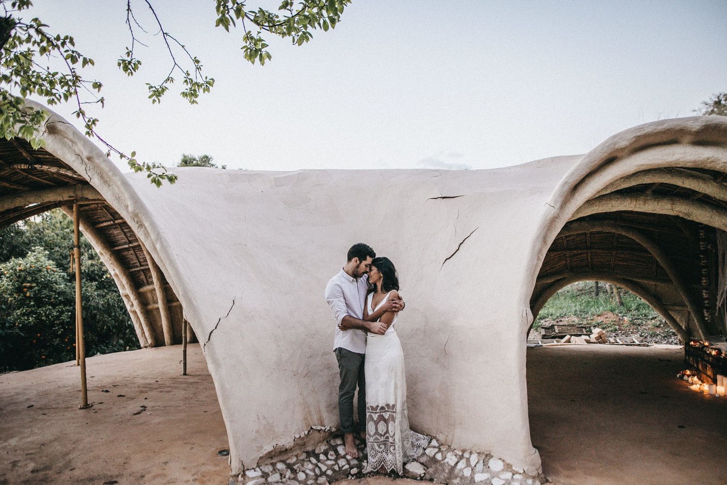 Romantic couple embracing in arched architectural setting.