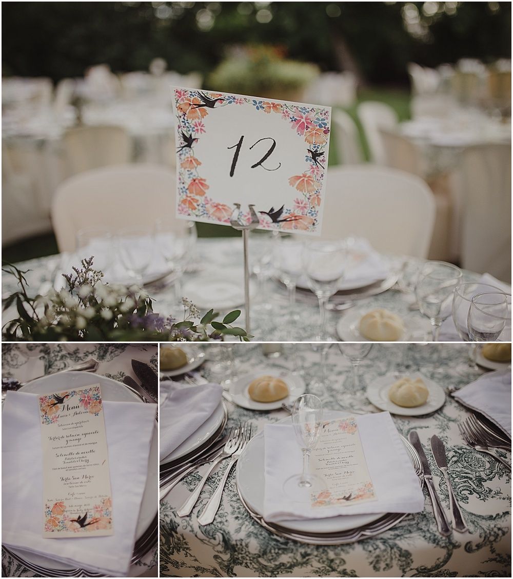 Wedding reception table setting with floral table number and delicate place settings.