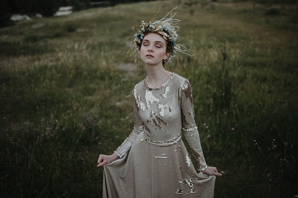 Vintage-inspired dress with delicate details against a pastoral mountain landscape.