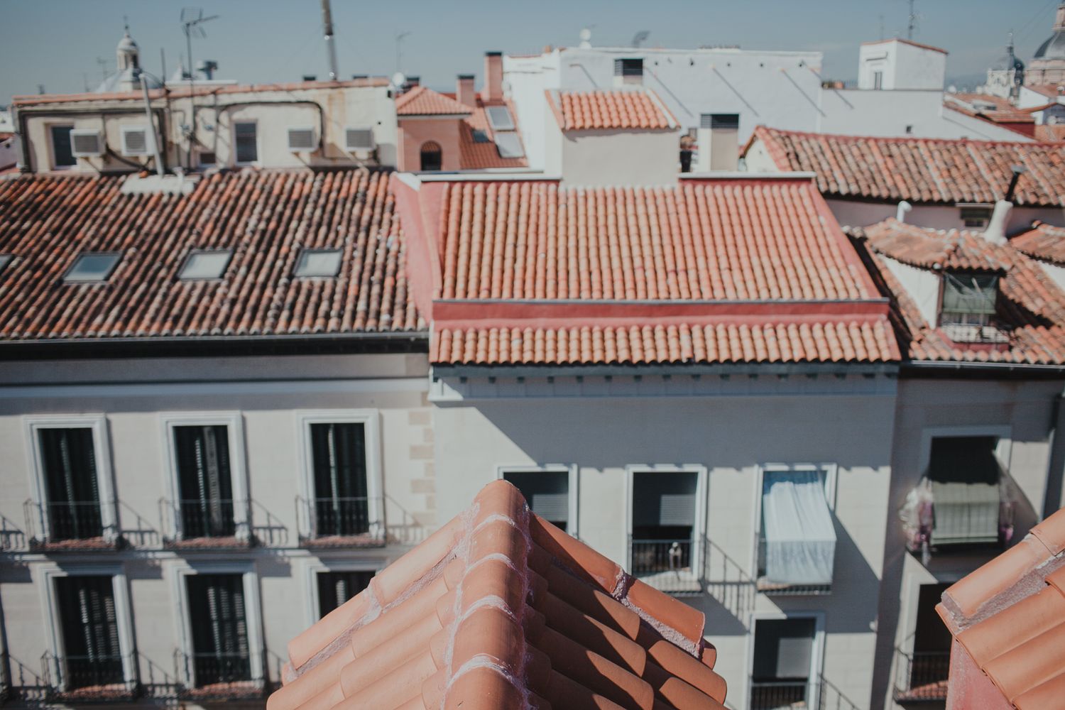 Aerial view of traditional Spanish buildings with terracotta roofs and white facades.