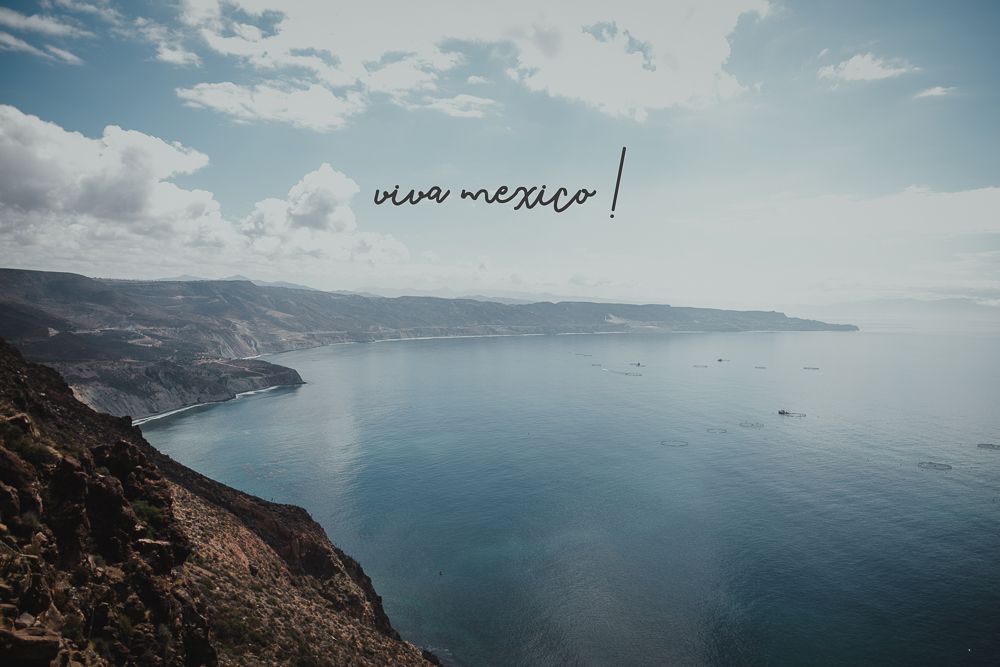 Coastal landscape overlooking ocean cliffs with text overlay reading 'new mexico' against blue sky.