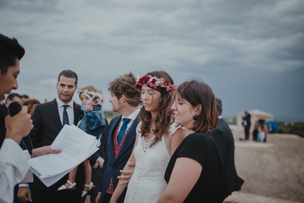 Wedding ceremony participants gather around during an outdoor rooftop service.