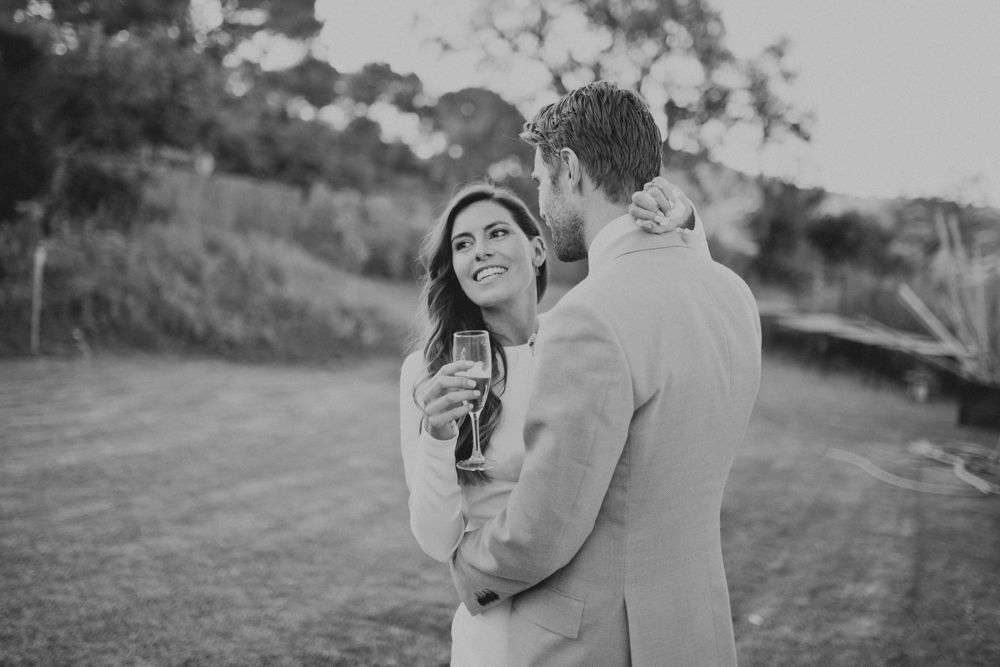 Black and white image of a couple sharing an intimate moment during an outdoor event.