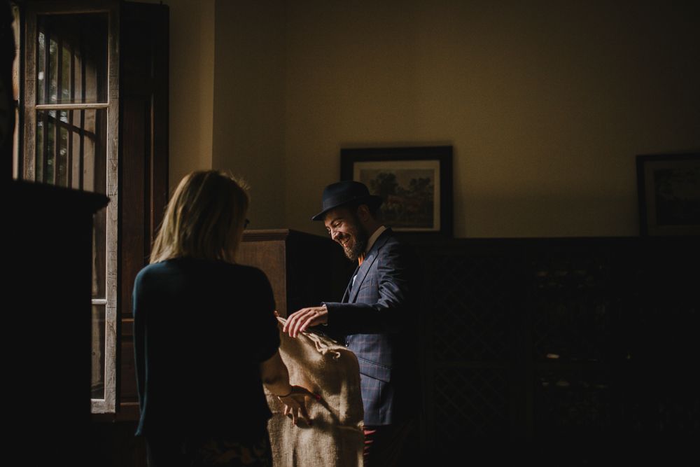 Two people in a dimly lit vintage room examining papers together.