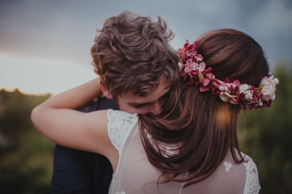 An intimate wedding photo showing a tender embrace during golden hour.
