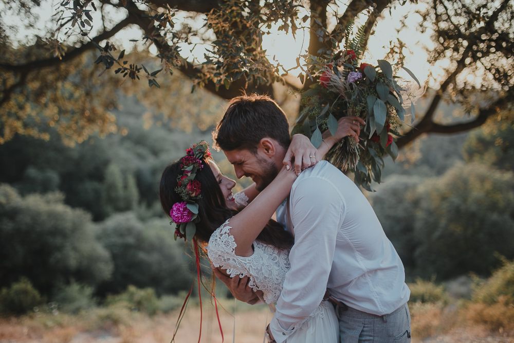 Tender wedding moment photographed against natural forest backdrop at golden hour.