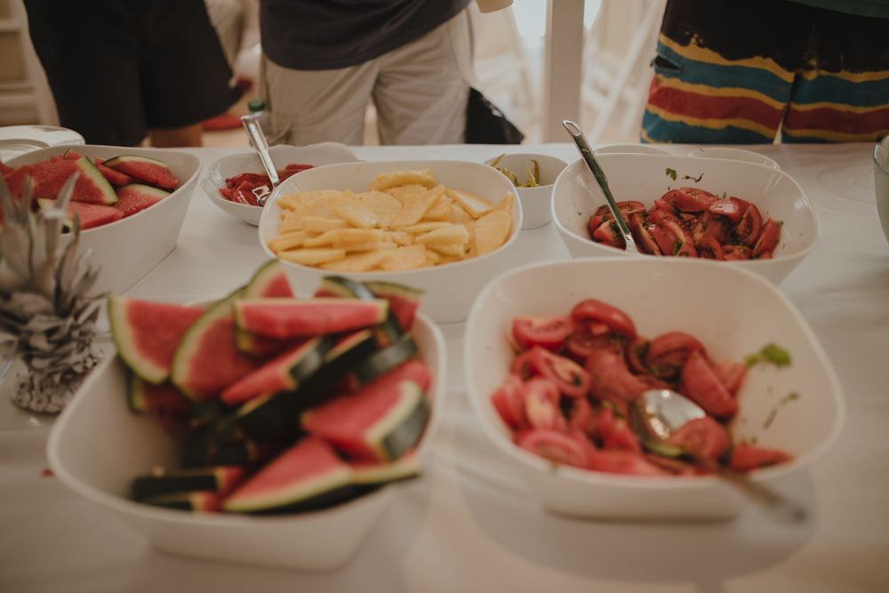 Fresh summer party spread with watermelon slices and appetizers on white serving plates.