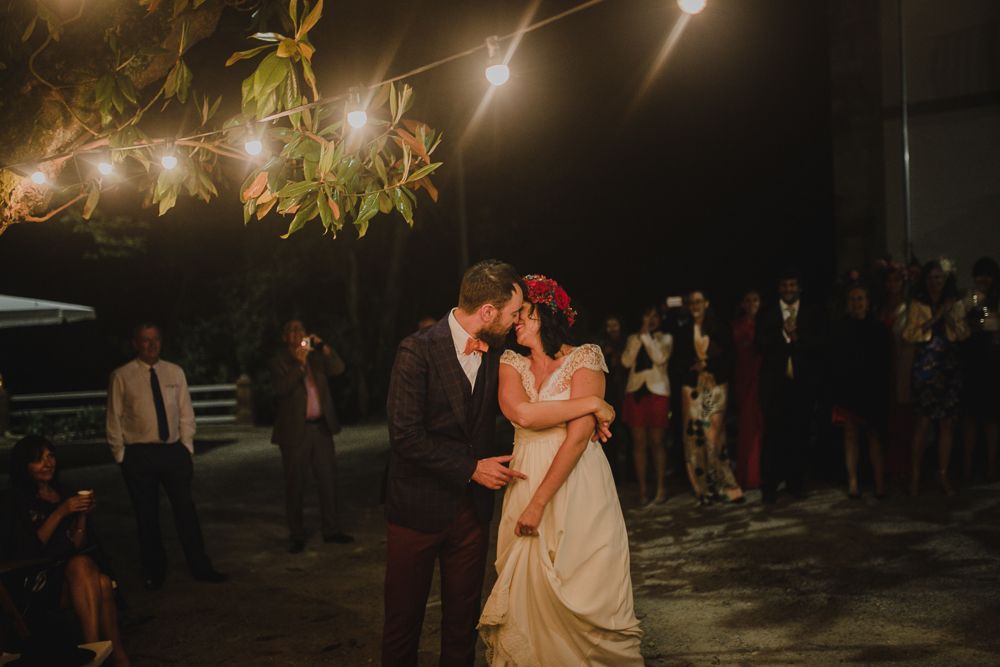 A romantic wedding dance under twinkling string lights at an evening outdoor reception.