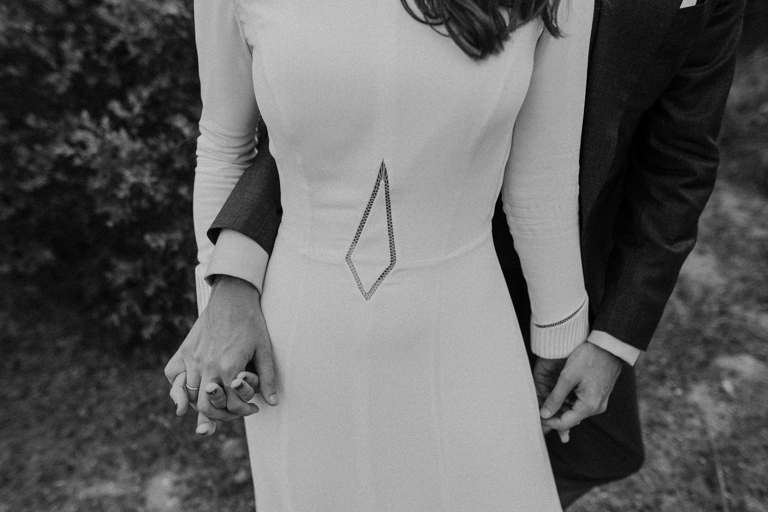 A close-up detail shot of an elegant white wedding dress with geometric design.