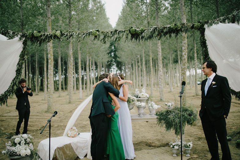 Forest wedding ceremony with white and green decor surrounded by aspen trees.