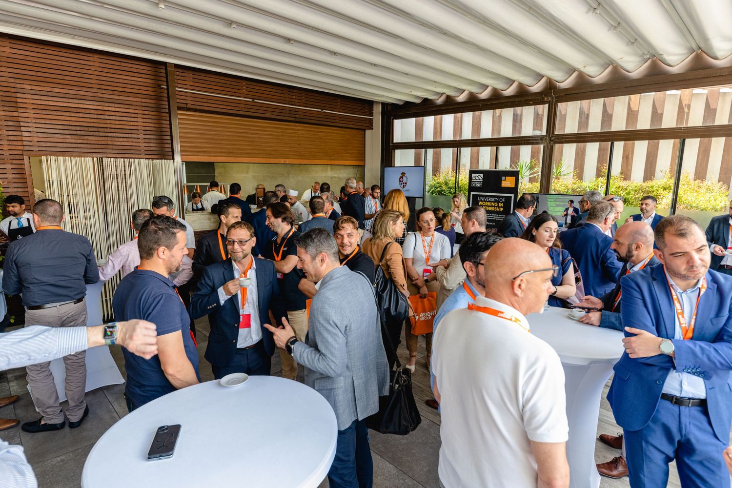 Business professionals networking at a crowded indoor corporate event.