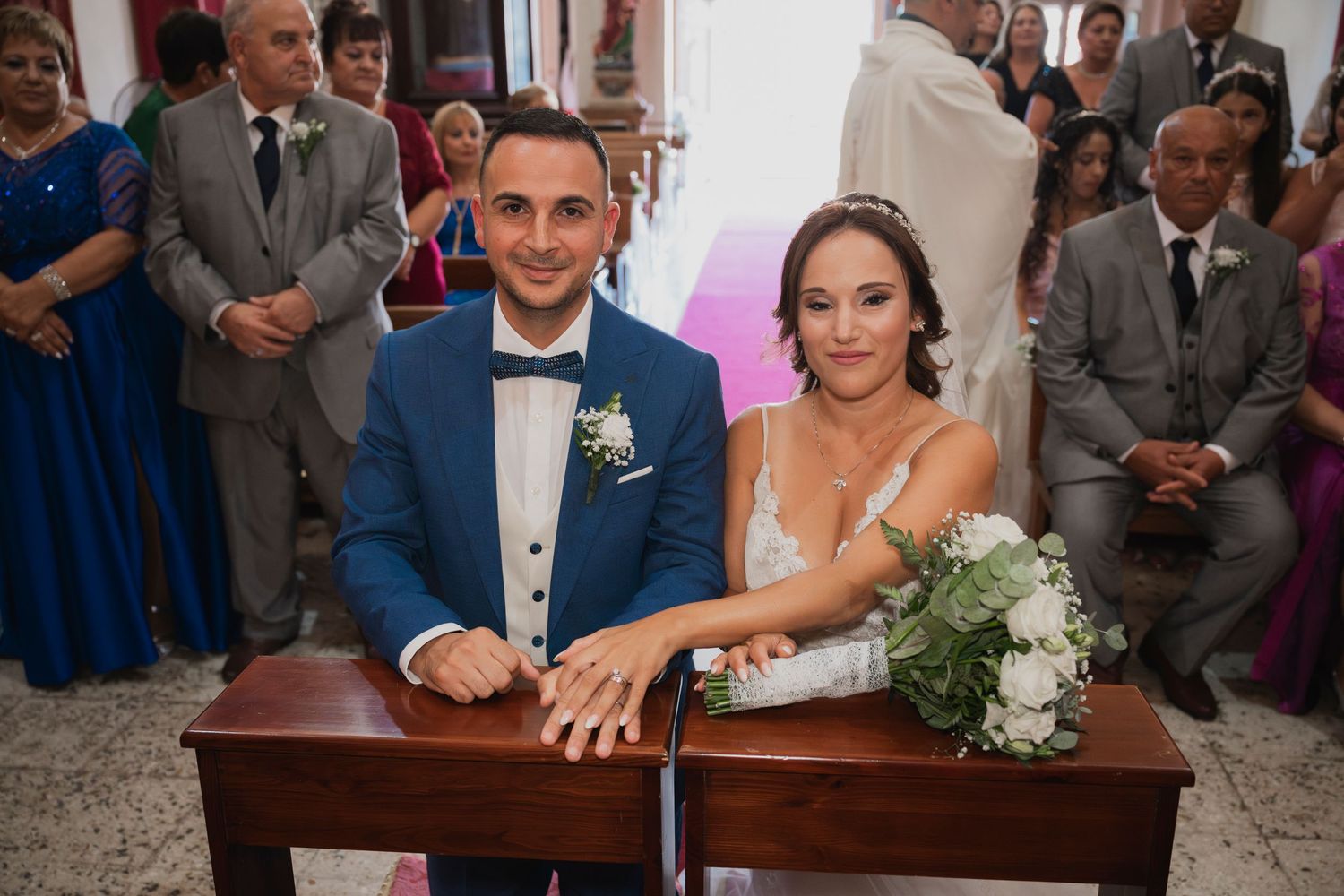 Wedding party gathered around a signing table during the marriage ceremony.
