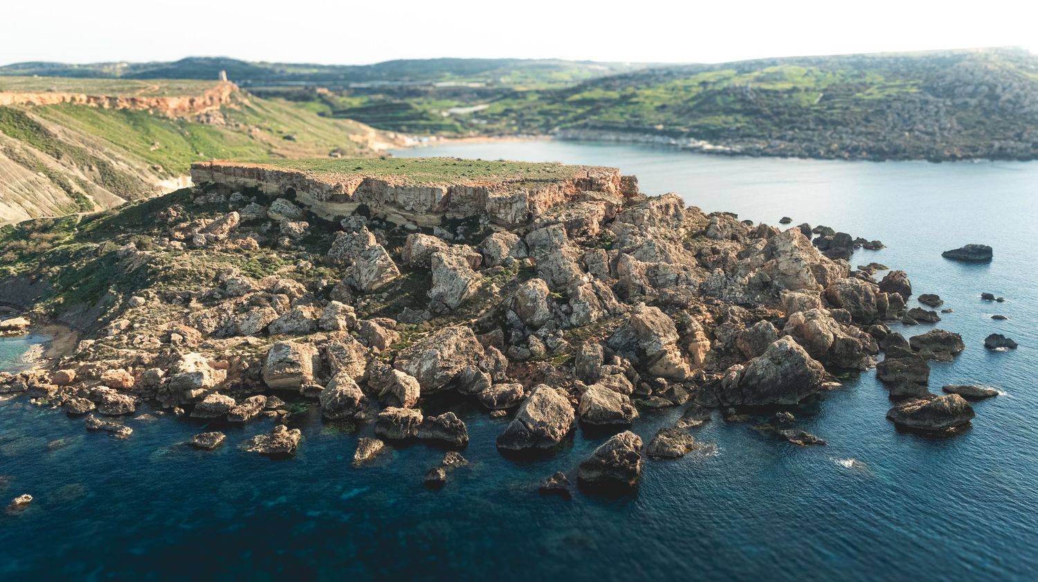 Wide panoramic view of dramatic coastal cliffs and bays stretching along the Mediterranean coastline.