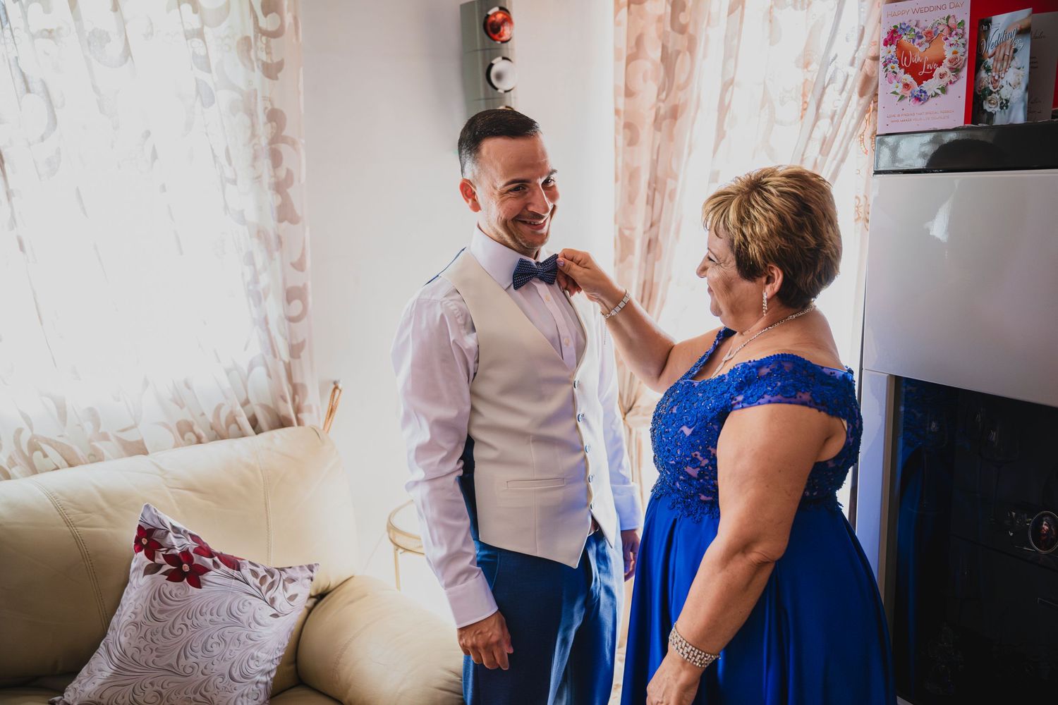 Wedding preparation scene in a room with blue and white formal attire.