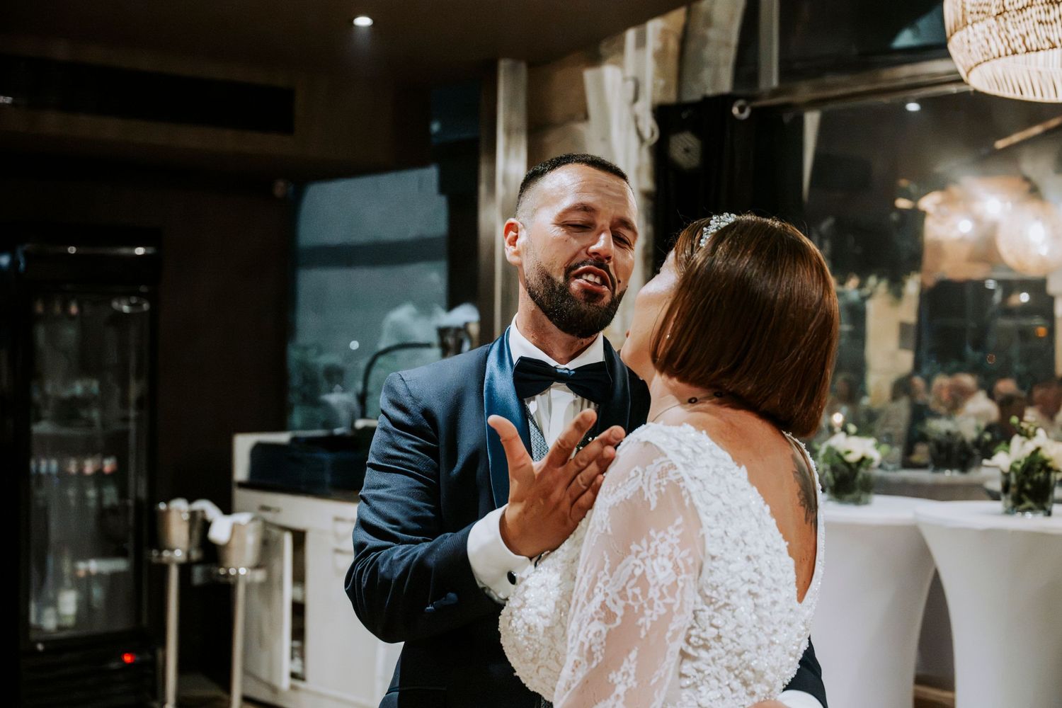 Bride and groom sharing a tender moment during their first dance at an elegant indoor wedding reception.