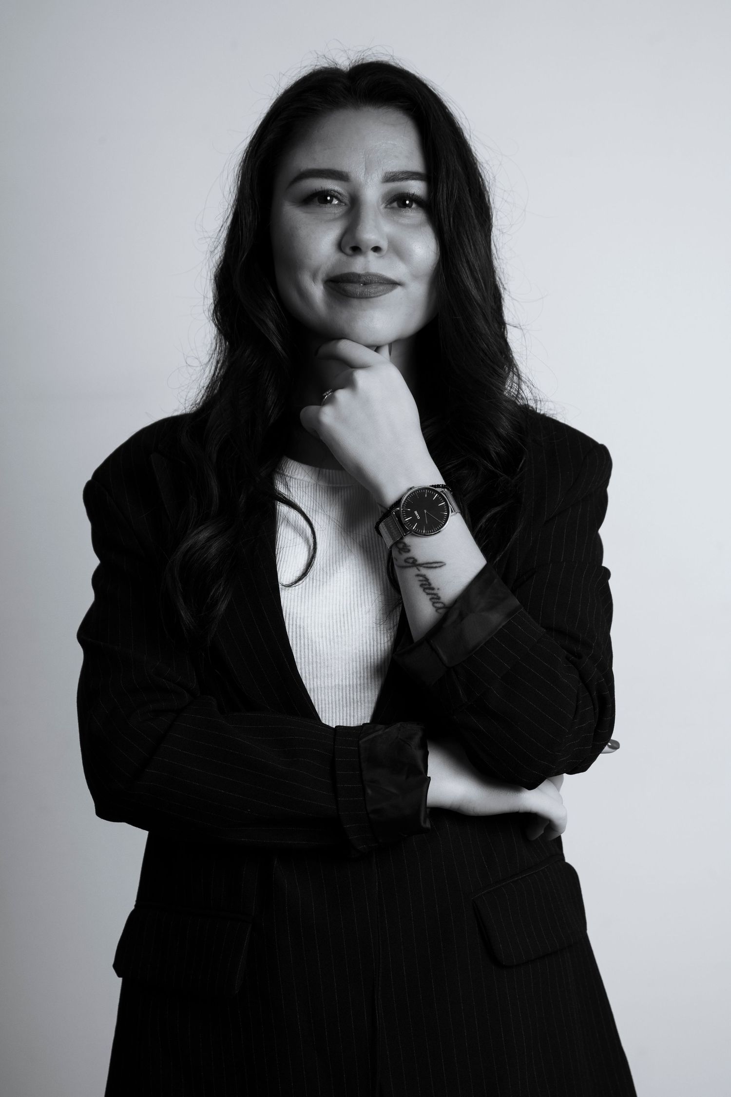 A series of black and white portraits showing a person in dark clothing against a light background posing expressively.