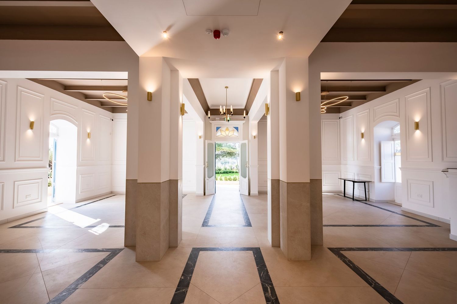 Long white corridor with recessed lighting and modern architectural details.