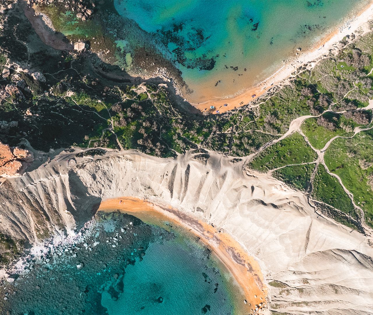 Aerial view of a dramatic coastline with turquoise waters and sandy beaches.