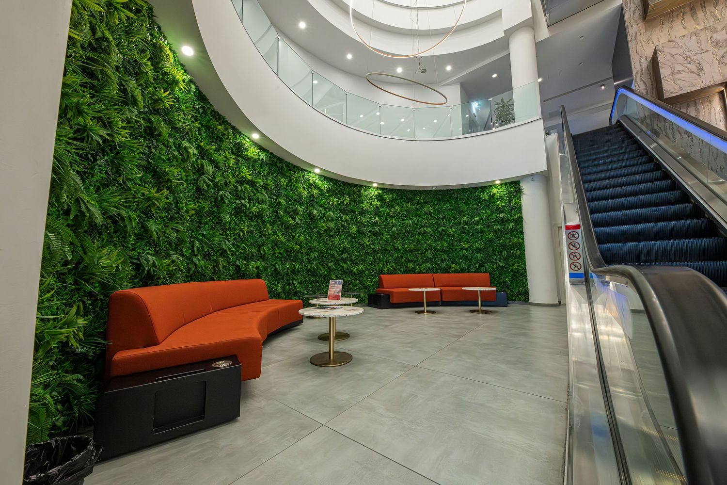 Modern office space featuring vibrant green wall panels and circular ceiling lights in a contemporary design.