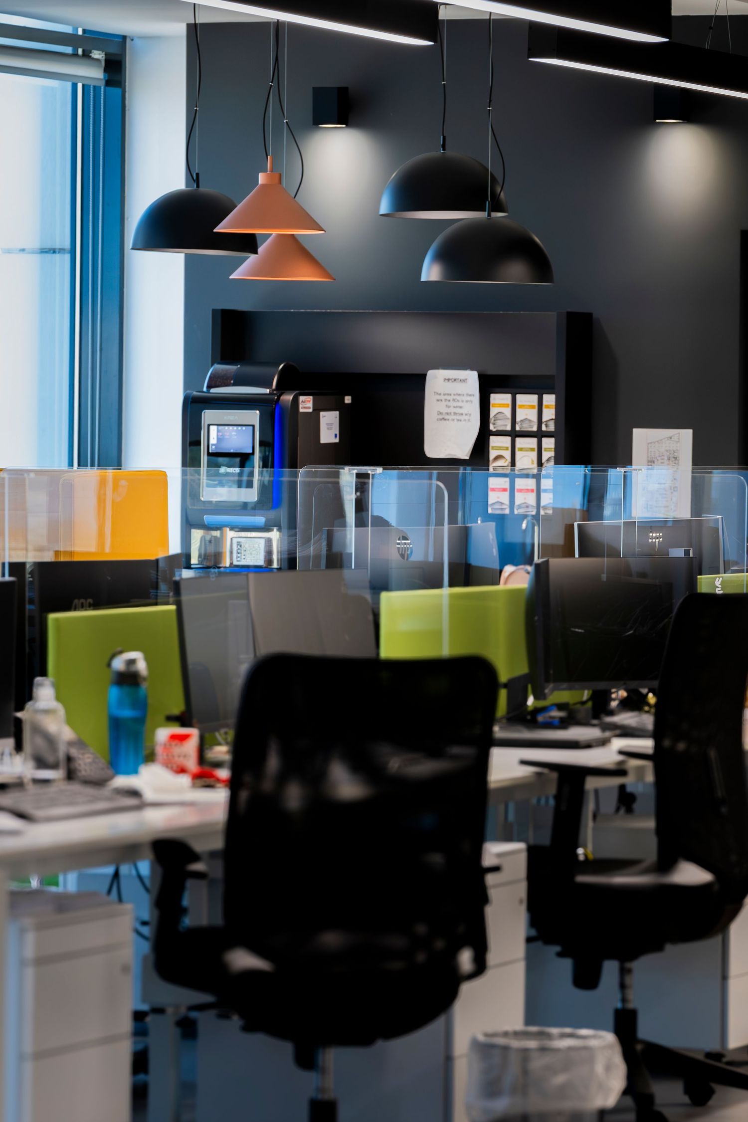 Contemporary office workspace with colorful partitions and ergonomic furniture.