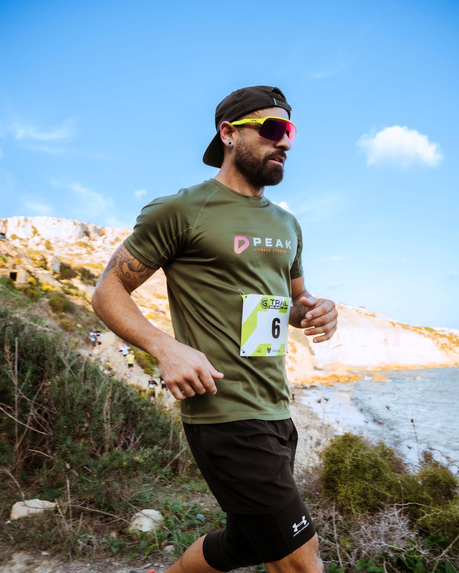 Athletes running along a scenic coastal trail during an outdoor competition.