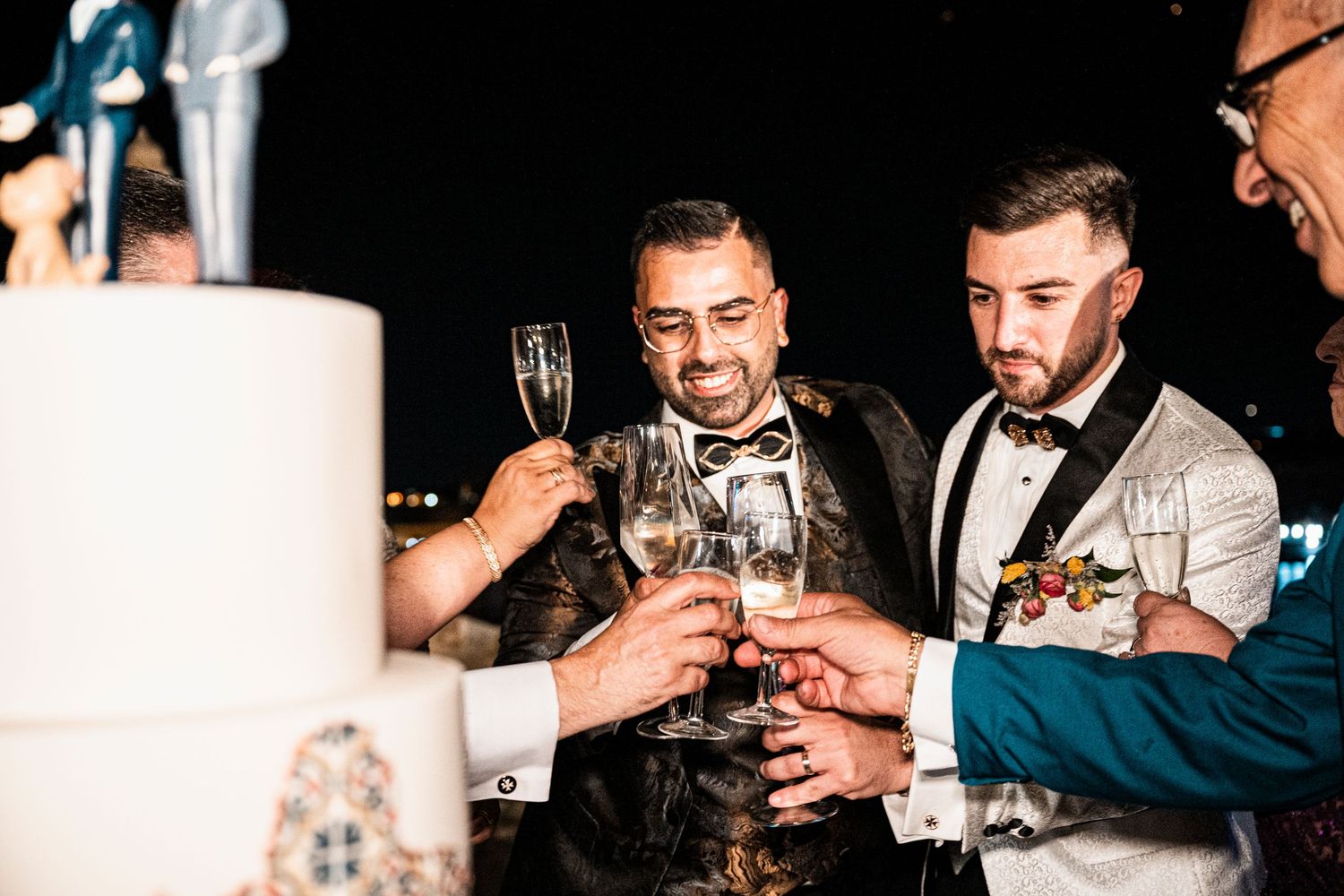 Evening celebration with guests in formal attire toasting with champagne glasses.