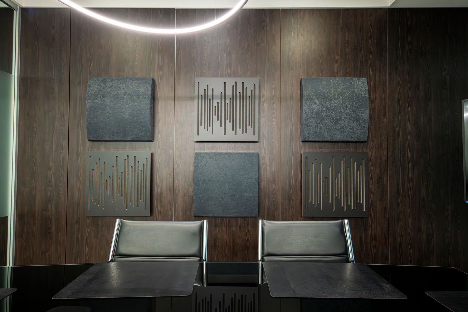Elegant conference room with dark wood paneling and minimalist lighting fixtures.