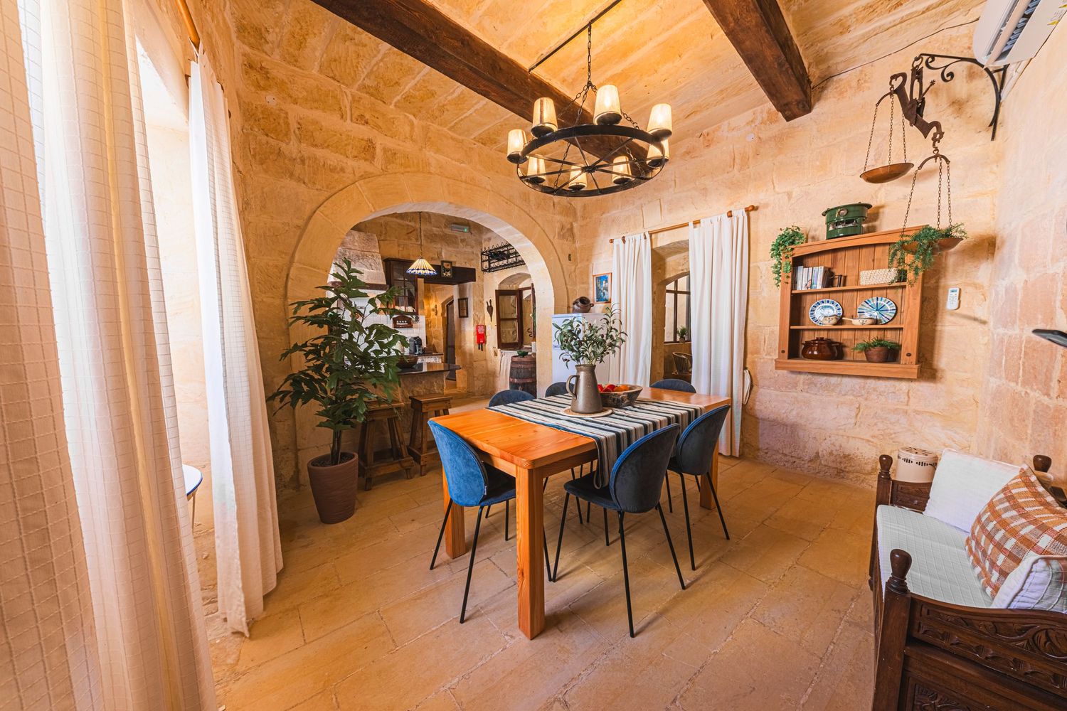 Mediterranean style dining room with stone walls, arched doorways and modern furniture.