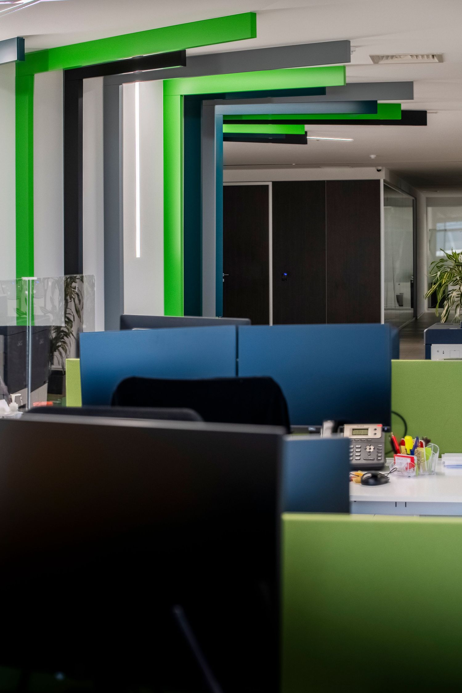 Sleek office interior with bright green accents and dark furniture creating a modern workspace environment.
